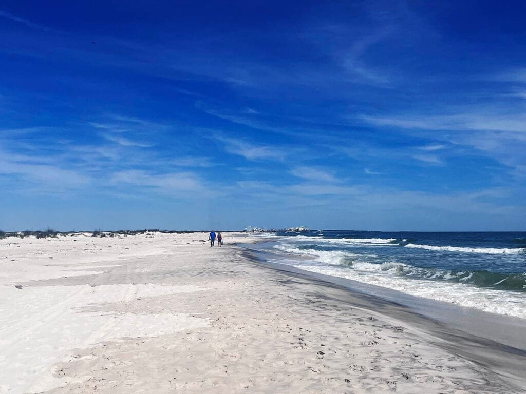 A couple walking on Dauphin Island's West End Beach | atlantaandbeyond.com